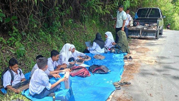 Pelajar SMP Negeri 28 Takengon di Kemukiman Pamar, Kecamatan Rusip Antara, Kabupaten Aceh Tengah, belajar di atas jalan.