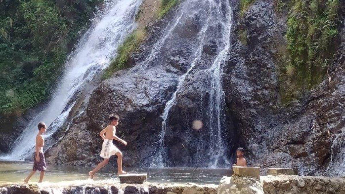 WISATA AIR - Warga setempat bermain di sekitar Air Terjun Sewawar, Sabtu (8/1/2022). Air Terjun Sewawar dan Sedinding berada di Desa Trengguli, Kecamatan Jenawi, Kabupaten Karanganyar.