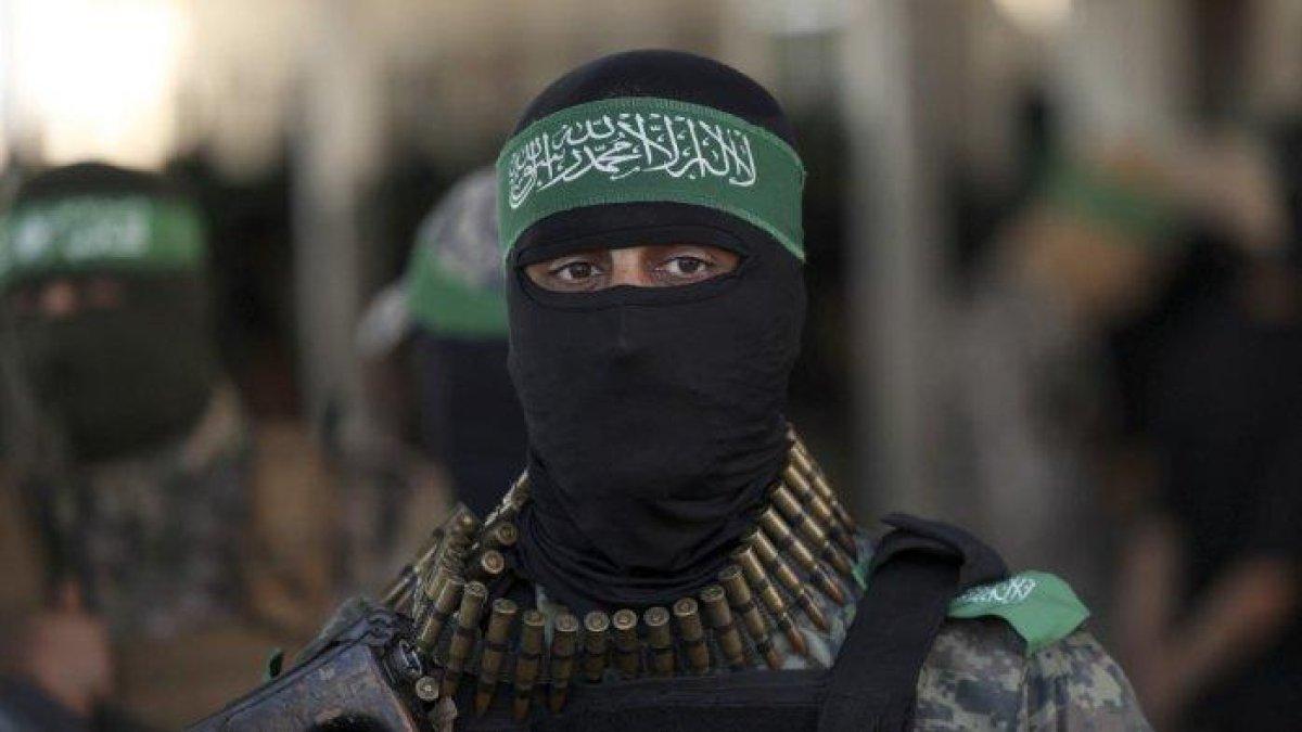 Anggota Brigade al-Qassam, sayap militer Hamas, yang bertopeng, berbaris saat unjuk rasa di Kota Gaza pada 20 Juli 2022.