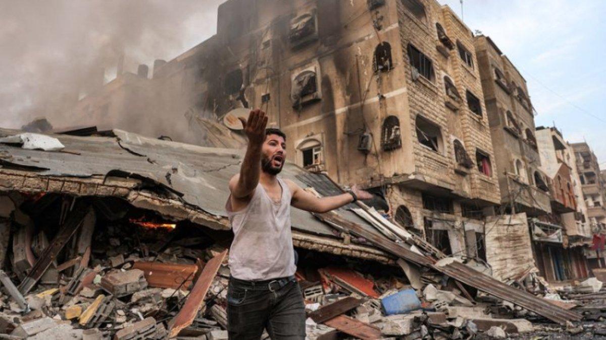 Seorang pria bereaksi di depan bangunan yang terbakar setelah dibombardir Israel di Kota Gaza