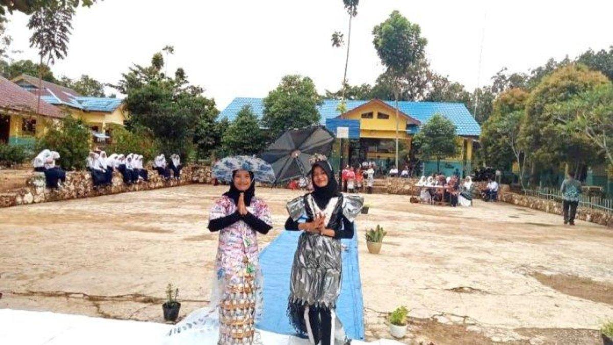Dua siswa SMPN 3 Batumandi menggunakan pakaian dari plastik bekas. Simak kunci jawaban UTS IPS semester 1 kelas 9