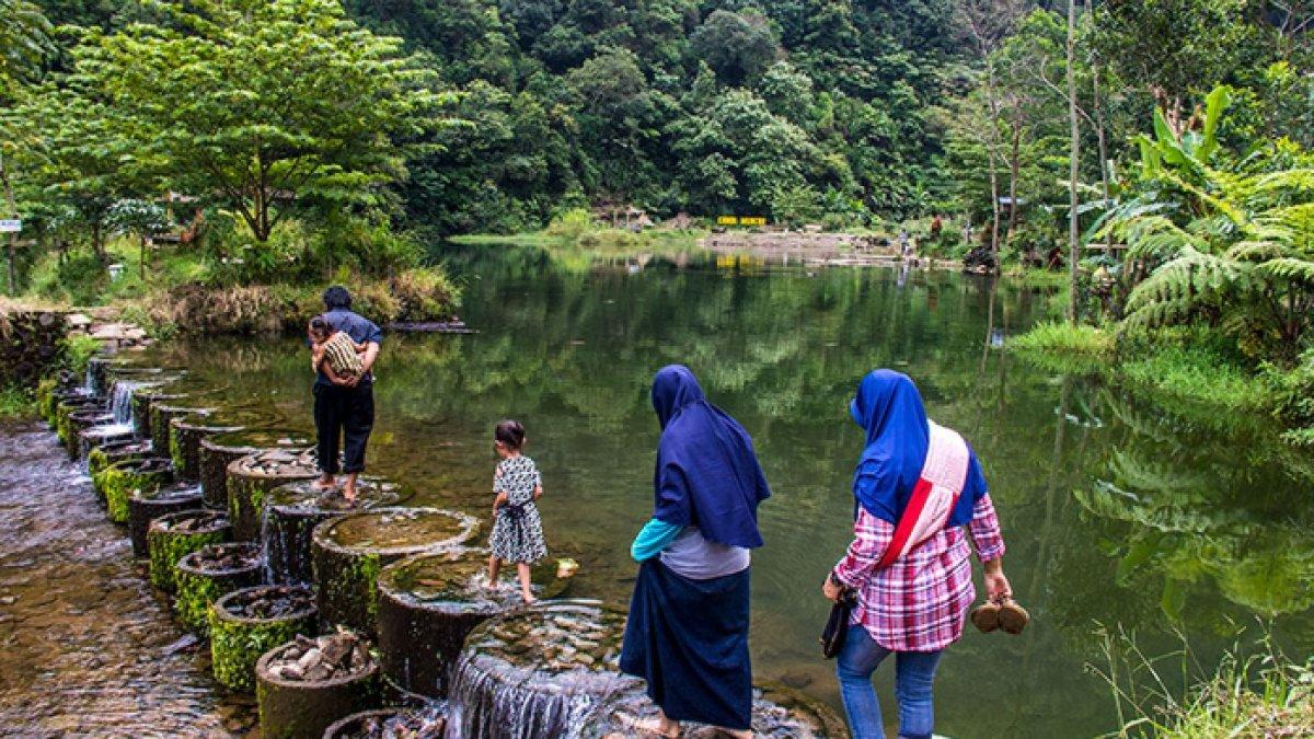 WISATA ALAM - Potret pengunjung melintas di atas Bendungan Candi Muncar, disadur dari Kompas.com pada Minggu (9/3/2025). Bendungan Candi Muncar berada di Kecamatan Girimarto, Wonogiri.