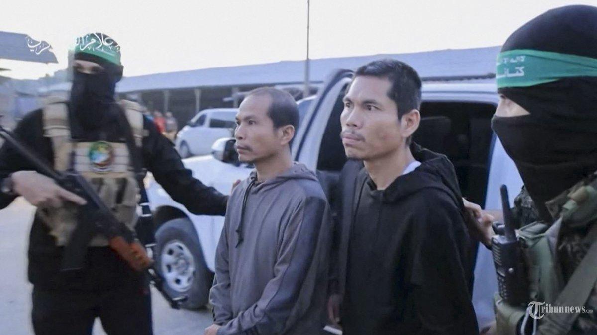 Gambar yang diambil dari video selebaran yang dirilis oleh Kantor Media Hamas menunjukkan anggota Brigade Al-Qassam menyandera pejabat Komite Palang Merah Internasional di Gaza pada 24 November 2023, sebelum mereka dipindahkan ke Israel. Setelah 48 hari baku tembak dan pemboman yang merenggut ribuan nyawa, sandera pertama yang dibebaskan berdasarkan kesepakatan gencatan senjata antara Israel dan Hamas diserahkan pada 24 November, kata kedua belah pihak, hampir tujuh minggu setelah mereka ditangkap.
