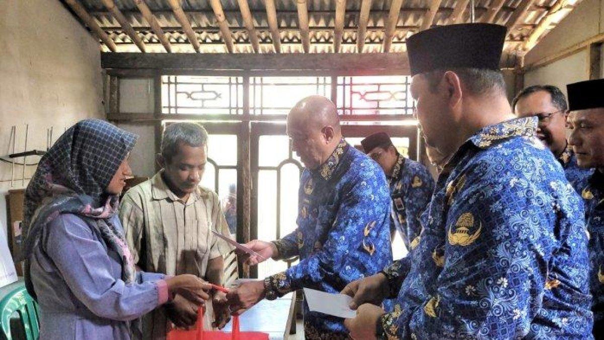 100 HARI KERJA - Bupati Banyumas, Sadewo Tri Lastiono menyerahkan secara langsung bantuan kepada Jamaludin, seorang penderes yang jatuh dari pohon kelapa, Senin (17/3/2025). Jamaludin ini mengalami kecelakaan saat bekerja sebagai penderes pada 25 Februari 2025 lalu.