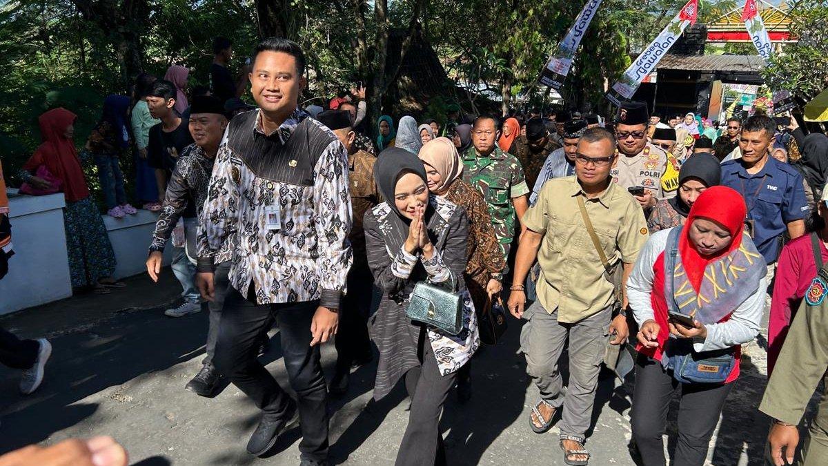 SYAWALAN DI KLATEN - Bupati Klaten Hamenang Wajar Ismoyo bersama istri, Fahrani Hamenang Wajar Ismoyo menyapa warga saat memimpin kirab gunungan ketupat Grebeg Syawalan di Bukit Sidoguro, Desa Krakitan, Kecamatan Bayat, Klaten pada Senin (7/4/2025).