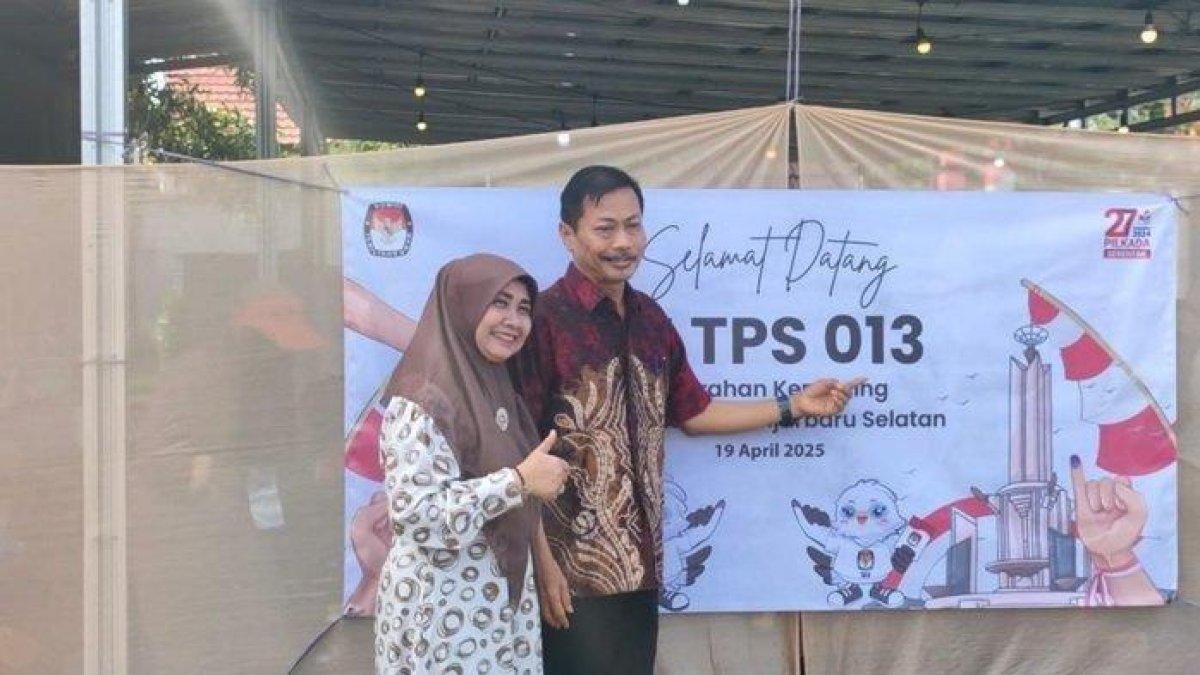 PEMUNGUTAN SUARA ULANG - Calon Wakil Wali Kota Banjarbaru, Wartono didampingi istri foto bersama sebelum mencoblos di TPS 013, Kemuning, Banjarbaru, Sabtu, (19/04/2025).