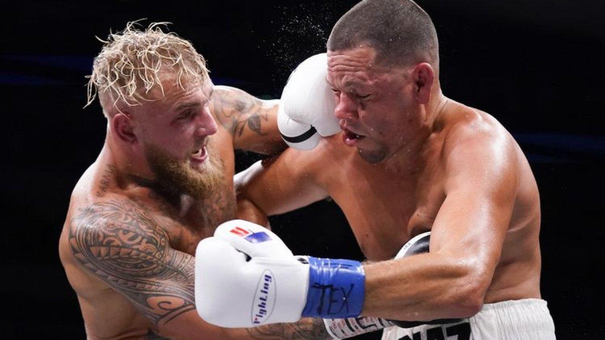 Jake Paul (kiri) dan Nate Diaz bertukar pukulan pada ronde ketiga pertarungan mereka di American Airlines Center pada 5 Agustus 2023 di Dallas, Texas.