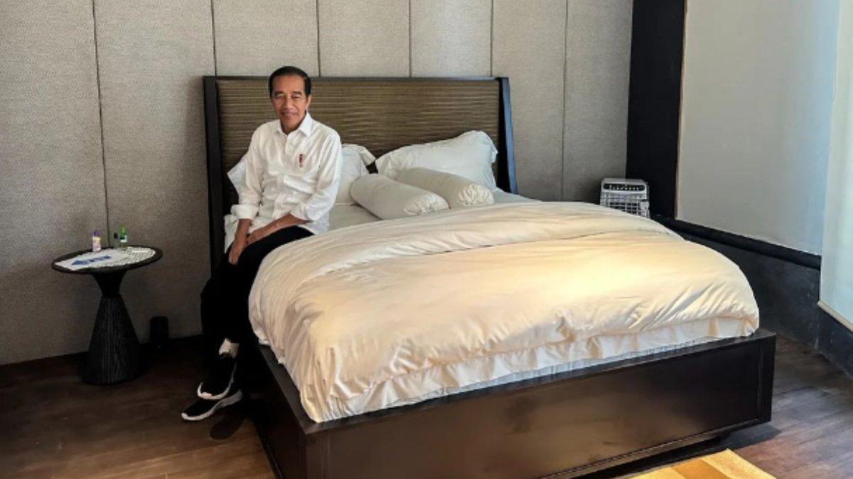 Jokowi tampak duduk di atas tempat tidur bersprei putih