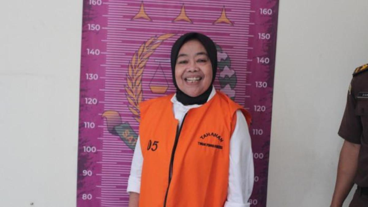 TERSANGKA KORUPSI - Kepala Desa Cikujang, Kabupaten Sukabumi, Heni Mulyani, tersenyum lebar saat difoto memakai rompi tahanan pidsus Kejari Kab Sukabumi. Heni ditetapkan tersangka kasus korupsi dana desa, Senin (28/7/2025).