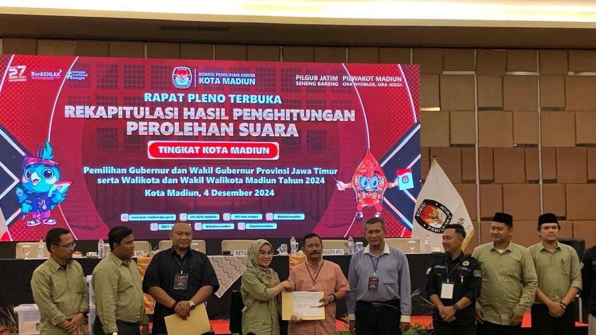Ketua KPU Kota Madiun, Pita Anjarsari menyerahkan rekapitulasi hasil perhitungan perolehan suara pilkada Kota Madiun yang digelar KPU Kota Madiun di Hotel Aston Madiun, Rabu (4/12/2024).
