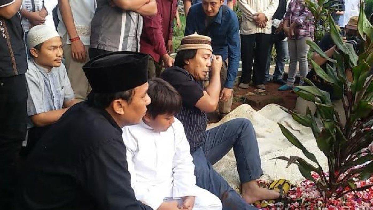 Komeng menangis di pusara anaknya