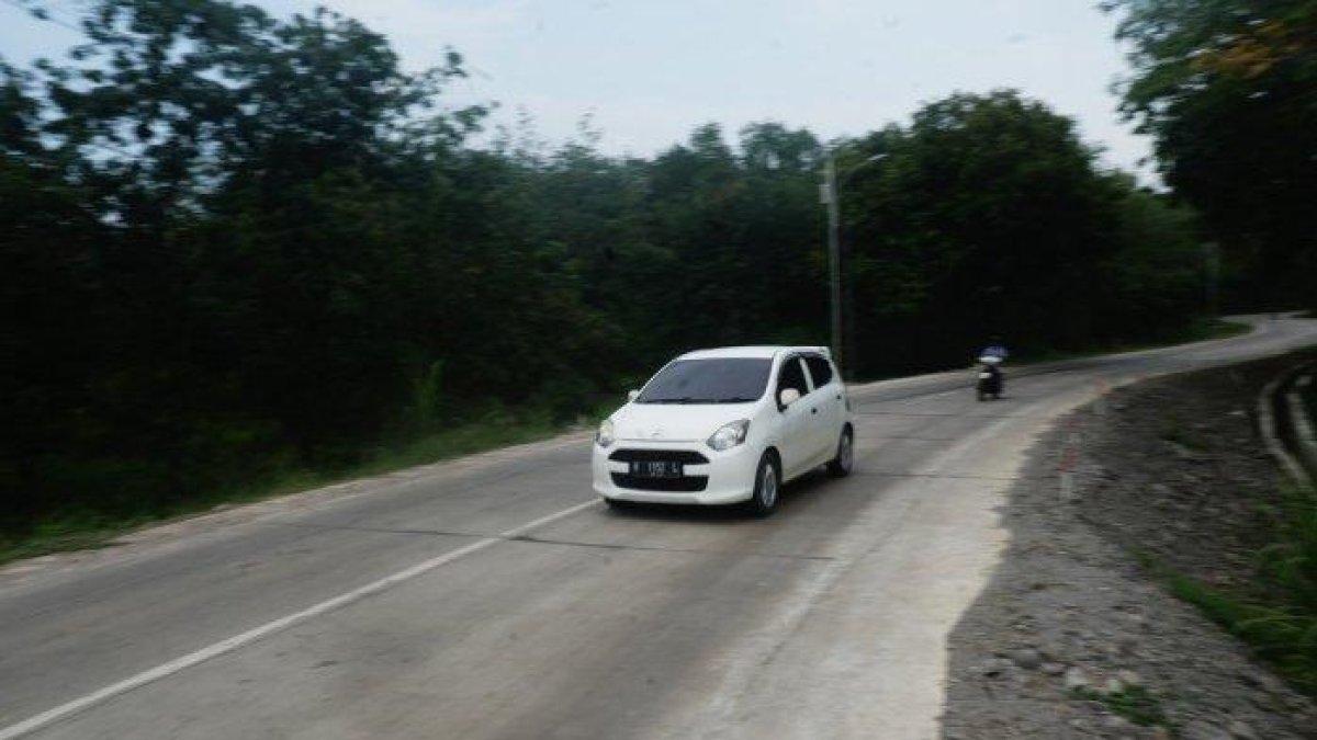 PROGRAM BUPATI PATI - Sebuah mobil dan sepeda motor melintasi Jalan Tayu-Puncel yang kondisinya sudah mulus pascaperbaikan.