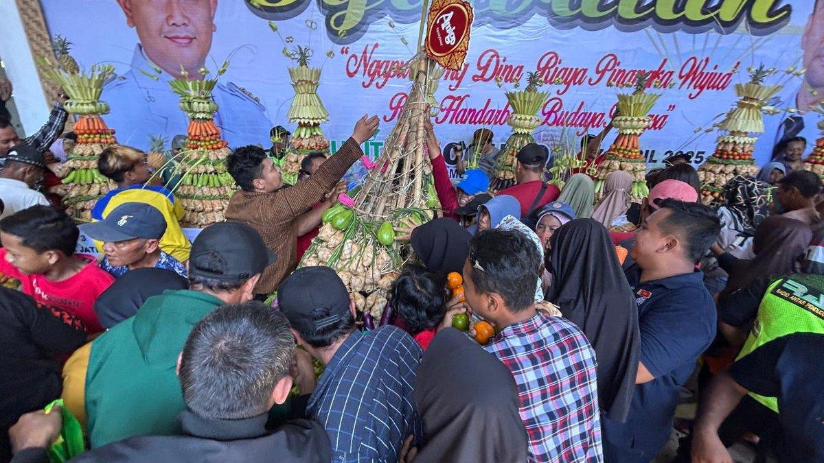 SYAWALAN DI KLATEN - Masyarakat menanti momen berebut ketupat yang disiapkan Pemerintah Kabupaten (Pemkab) Klaten pada Grebeg Syawalan di Bukit Sidoguro, Desa Krakitan, Kecamatan Bayat, Klaten pada Senin (7/4/2025).