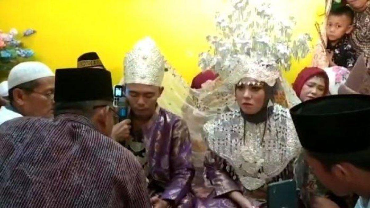 Kedua pasangan pengantin Hepriyadi (29 tahun) dan Herlina (20 tahun) saat menikah di depan penghulu, Minggu (8/12/2019). wali nikah perempuan berkomunikasi melalui video call.