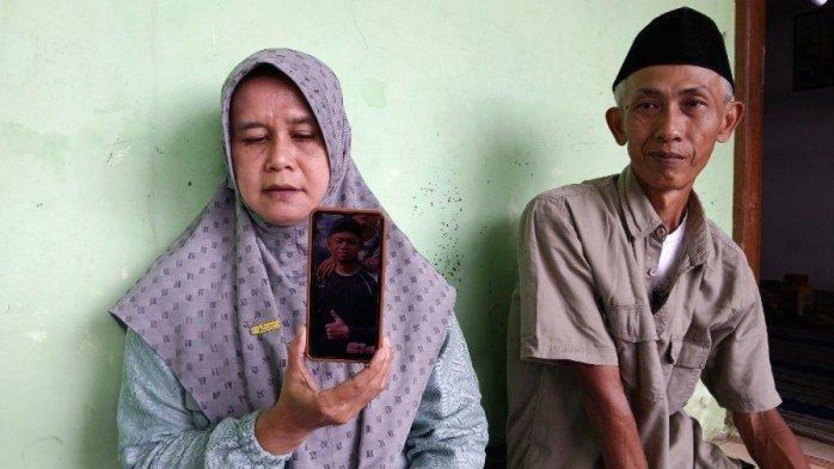 PERLIHATKAN FOTO - Noris Sumirah bersama suami, Sutanto memperlihatkan foto anak semata wayangnya yang hilang saat PKL, di rumahnya RT 05 RW 07 Kelurahan Panggung, Kota Tegal, Senin (7/7/2025). Anaknya bernama Mochamad Daffa Sanjaya hilang di Perairan Sumenep, Jawa Timur, saat ikuti PKL.