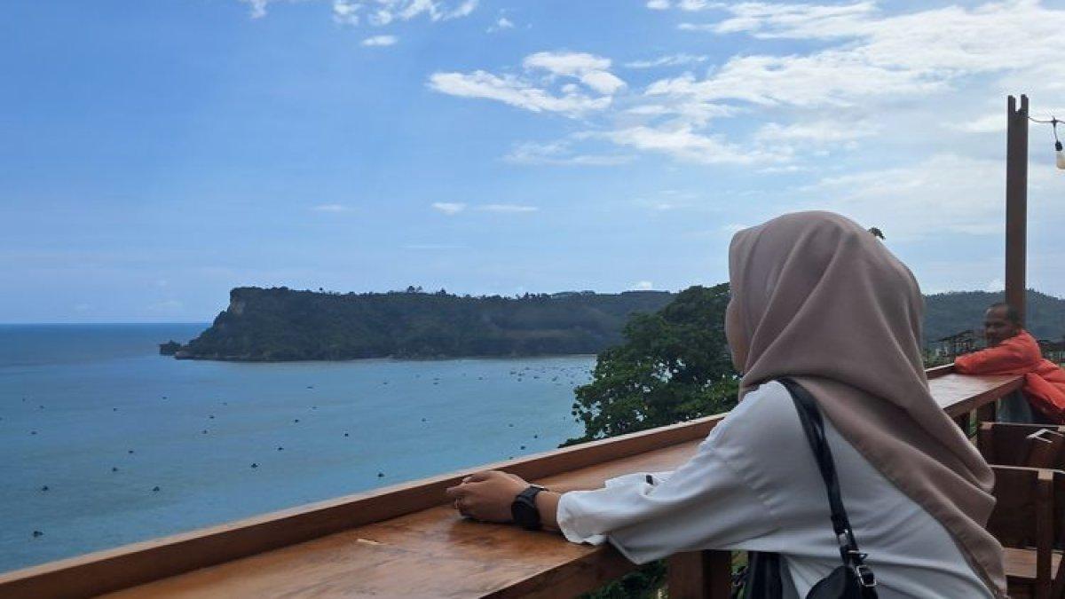 PANTAI SINE TULUNGAGUNG - Seorang wisatawan sedang menikmati pemandangan Pantai Sine Tulungagung dari Rooftop salah satu kafe