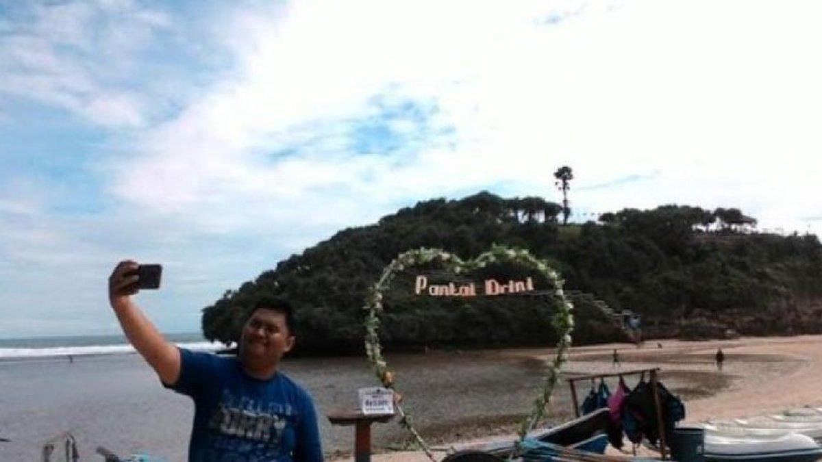 PANTAI DRINI - Wisatawan tengah berswafoto di Pantai Drini, Gunungkidul, DI Yogyakarta, Selasa (28/3/2017). Pantai Drini merupakan kawasan wisata pantai yang berada di Gunungkidul, Yogyakarta, dengan pemandangan pasir putih dan air laut yang jernih.