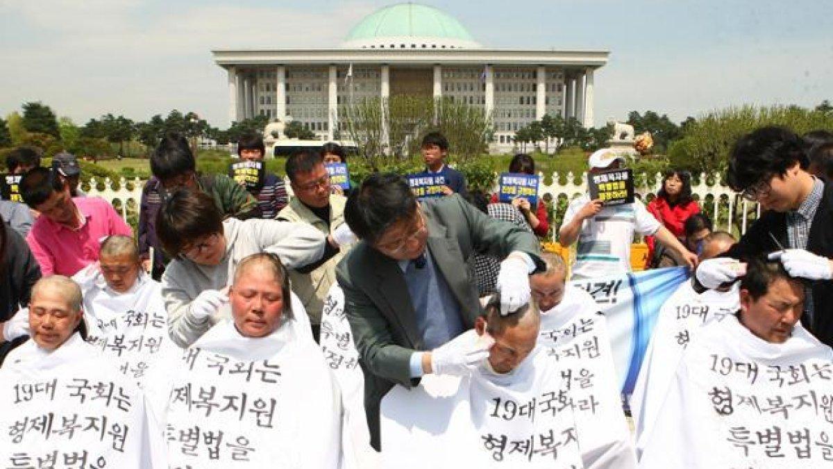Para penyintas Brothers Home mencukur rambut mereka di depan Majelis Nasional, 28 April 2015, untuk menuntut disahkannya Undang-Undang Khusus Brothers Home.