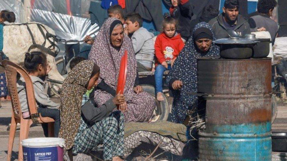 Pengungsi Palestina memasak di dapur darurat luar ruangan dekat tenda mereka di Rafah di Jalur Gaza selatan pada 24 Desember 2023, di tengah berlanjutnya pertempuran antara Israel dan kelompok militan Hamas.