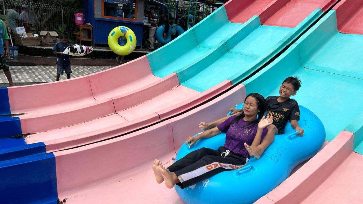 LIBUR LEBARAN KLATEN - Pengunjung bermain wahana seluncuran di kolam dengan kedalaman 1 meter, panjang 15 meter, tinggi sekira 4 meter, saat libur panjang Lebaran Umbul Pelem di Desa Wunut, Kecamatan Tulung, Klaten, Rabu (2/4/2025).