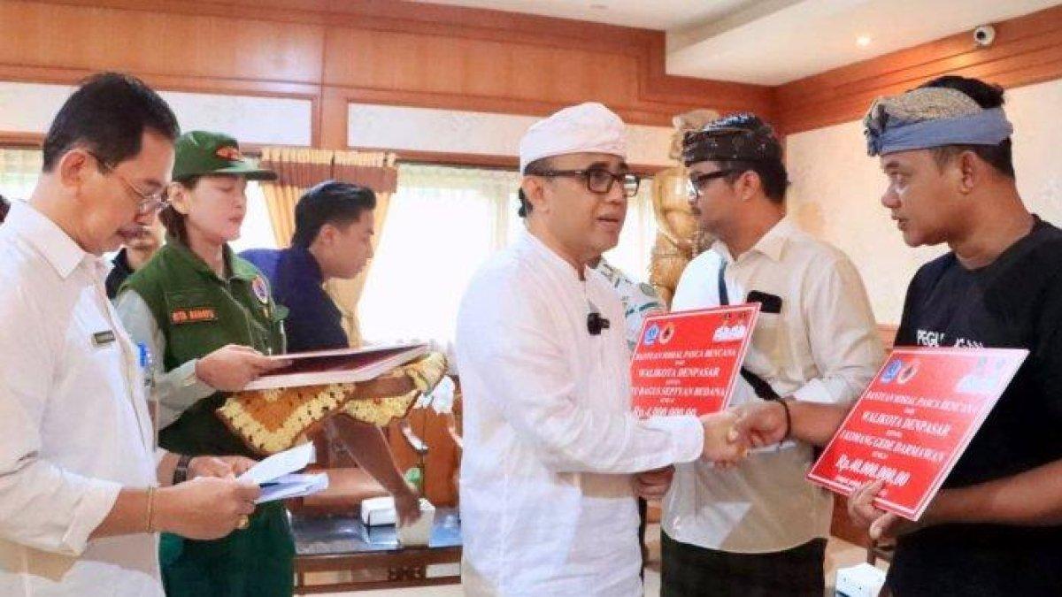 100 HARI KERJA - Penyerahan bantuan sosial pasca bencana di Denpasar beberapa waktu lalu.