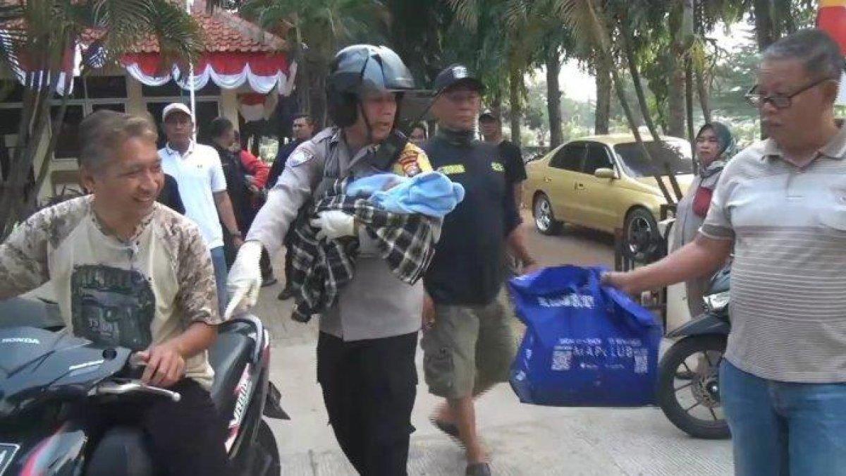 Personel Polsek Duren Sawit saat mengevakuasi bayi yang ditemukan terbungkus kardus di saluran air TPU Malaka, Minggu (6/8/2023)