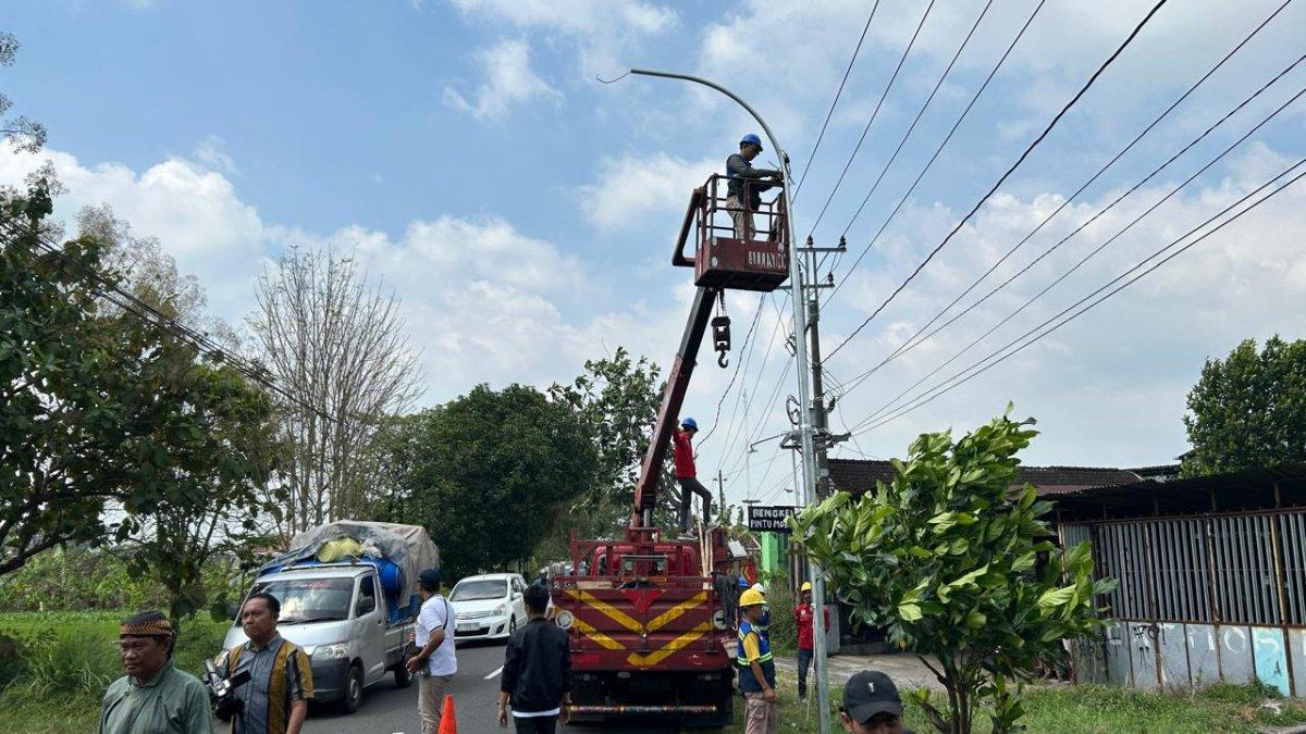 INFO KLATEN - Petugas Dishub Klaten melakukan instalasi penerangan jalan umum (PJU) berbasis listrik konvensional di ruas jalan Ngaran-Telukan, Kecamatan Trucuk, Klaten, pada Jumat (2/5/2025).