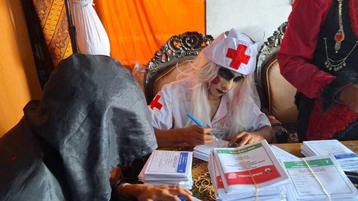 Petugas KPPS di TPS 5 Tepatnya di Jalan Raya Banjaran, Kampung Nambo, RT 03, RW 02, Desa Batukarut, Kecamatan Arjasari, Kabupaten Bandung, Jawa Barat mengenakan kostum hantu dan mendesain TPS seperti rumah hantu, Rabu (14/2/2024)