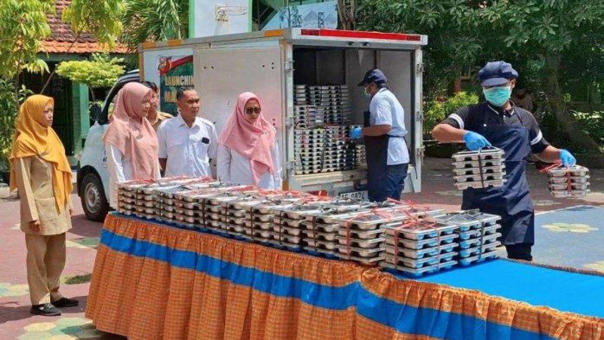 100 HARI KERJA - Petugas SPPG nampak menurunkan sejumlah paket program Makan Bergizi Gratis, yang dikemas dalam kotak besi diturunkan dari truk pick up, di SDN 02 Nambangan Lor Kota Madiun, Senin (6/1/2025). Wali Kota Madiun Maidi berencana menambah jumlah Satuan Pelayanan Pemenuhan Gizi (SPPG) sebagai program 100 hari kerja.