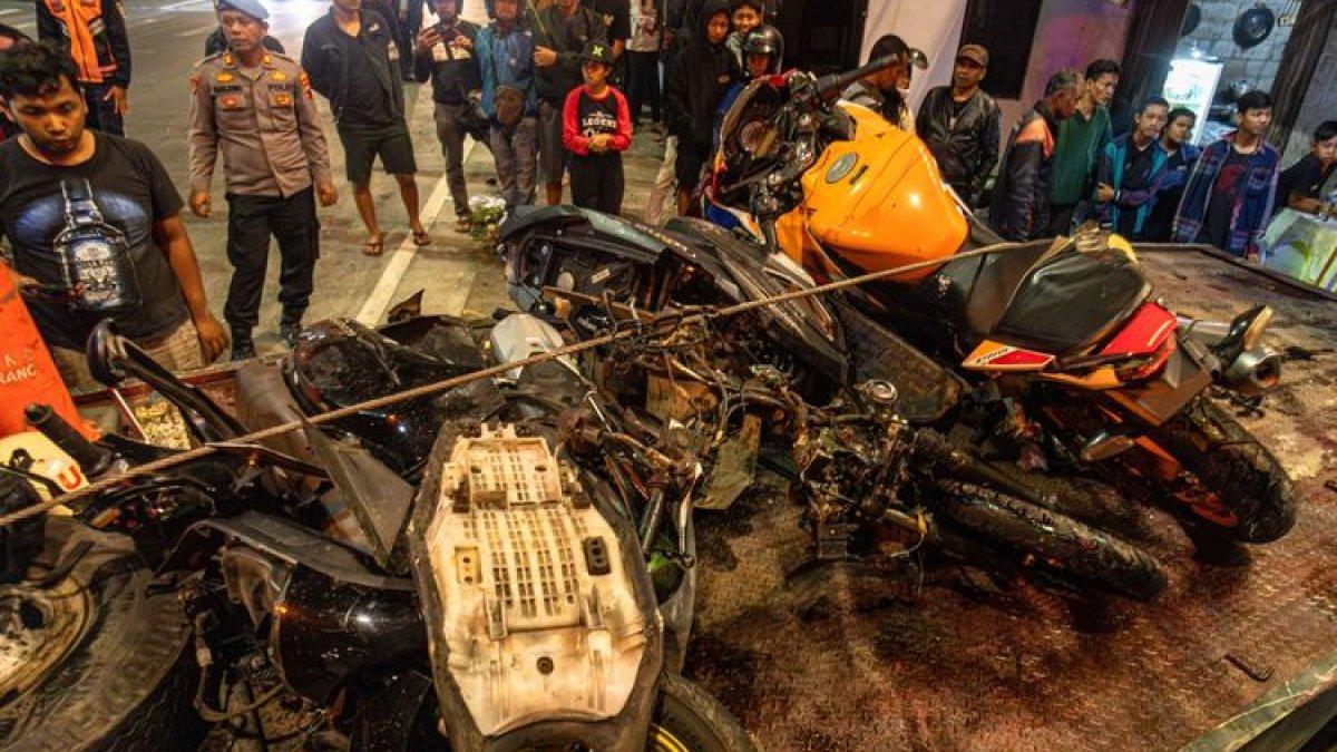 Petugas kepolisian dan relawan mengevakuasi kendaraan bermotor yang terlibat kecelakaan