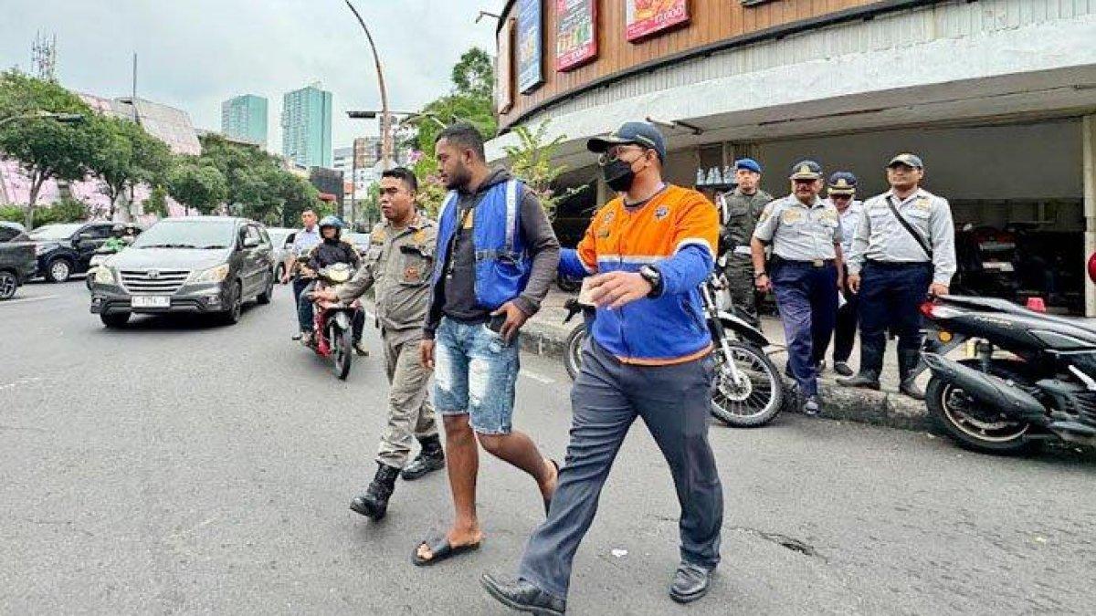 PROGRAM WALI KOTA SURABAYA - Petugas saat mengamankan juru parkir liar yang biasa beroperasi di minimarket-minimarket wilayah Surabaya, Jumat (30/5/2025). Sesuai regulasi yang berlaku di Surabaya, jukir resmi minimarket itu harus berseragam seusai dengan yang disediakan minimaket.
