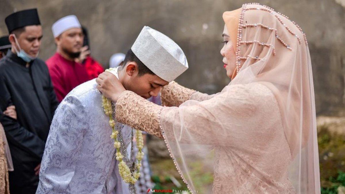 Rihanah saat mengalungkan bunga kepada Rozy.