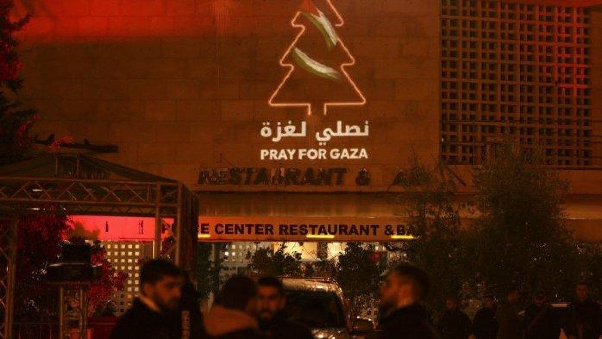 Sebuah pesan dukungan terhadap Gaza terpampang di sebuah bangunan di sebelah alun-alun Gereja Kelahiran di kota Betlehem yang menurut Alkitab di Tepi Barat yang diduduki pada 24 Desember 2023, menjelang misa tengah malam.