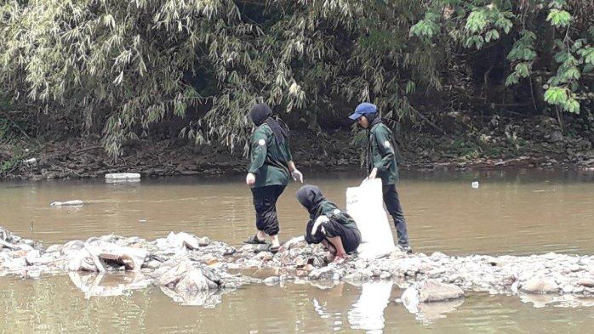 Sejumlah mahasiswa melakukan aksi bersih-bersih Sungai