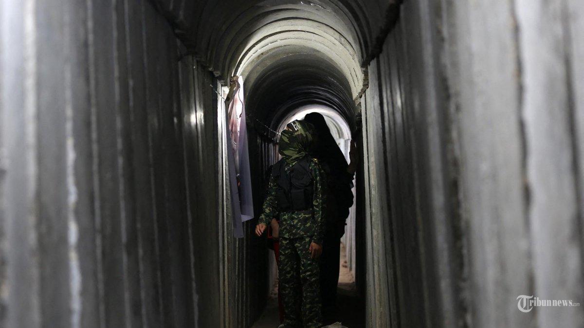 Seorang anak laki-laki Palestina berjalan di dalam terowongan yang digunakan untuk militer di kamp musim panas pemuda yang dikelola Hamas, di Kota Gaza