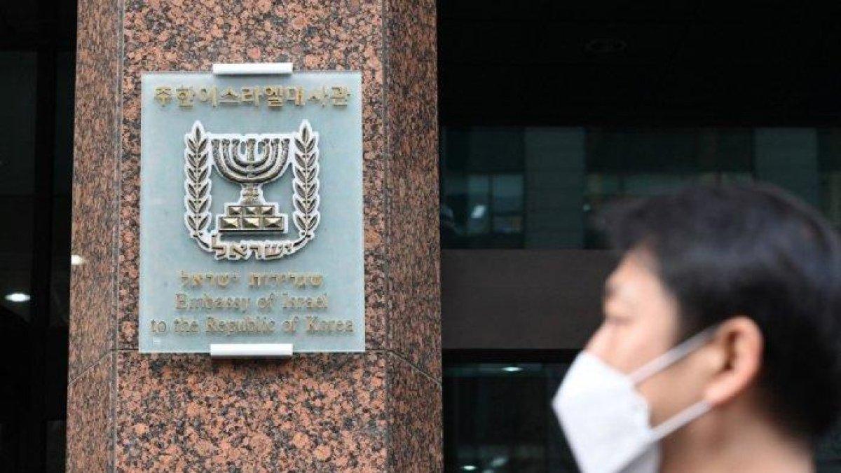 Seorang pria berjalan melewati kedutaan Israel di Seoul pada 28 Desember 2023. Kedutaan Israel di Korea Selatan telah menghapus video yang menunjukkan skenario khayalan di mana warga Korea diserang oleh penyerang bertopeng di Seoul, merujuk pada Hamas, kata kementerian luar negeri Seoul pada 28 Desember.