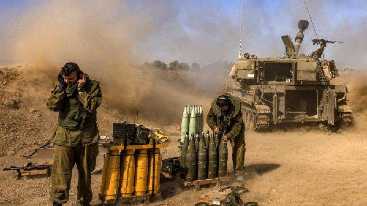 Seorang tentara Israel menutup telinganya saat howitzer artileri gerak sendiri menembakkan peluru dari posisi dekat perbatasan dengan Jalur Gaza di Israel selatan pada 6 November 2023 di tengah pertempuran yang sedang berlangsung antara Israel dan kelompok Palestina Hamas di Jalur Gaza.