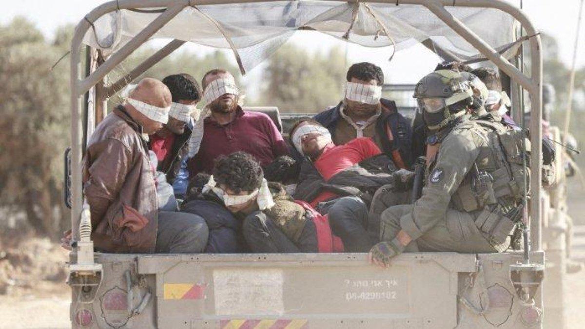 Tentara Israel memindahkan warga Palestina yang ditahan keluar dari Jalur Gaza pada 21 November 2023, di tengah pertempuran yang sedang berlangsung antara Israel dan gerakan Hamas Palestina.