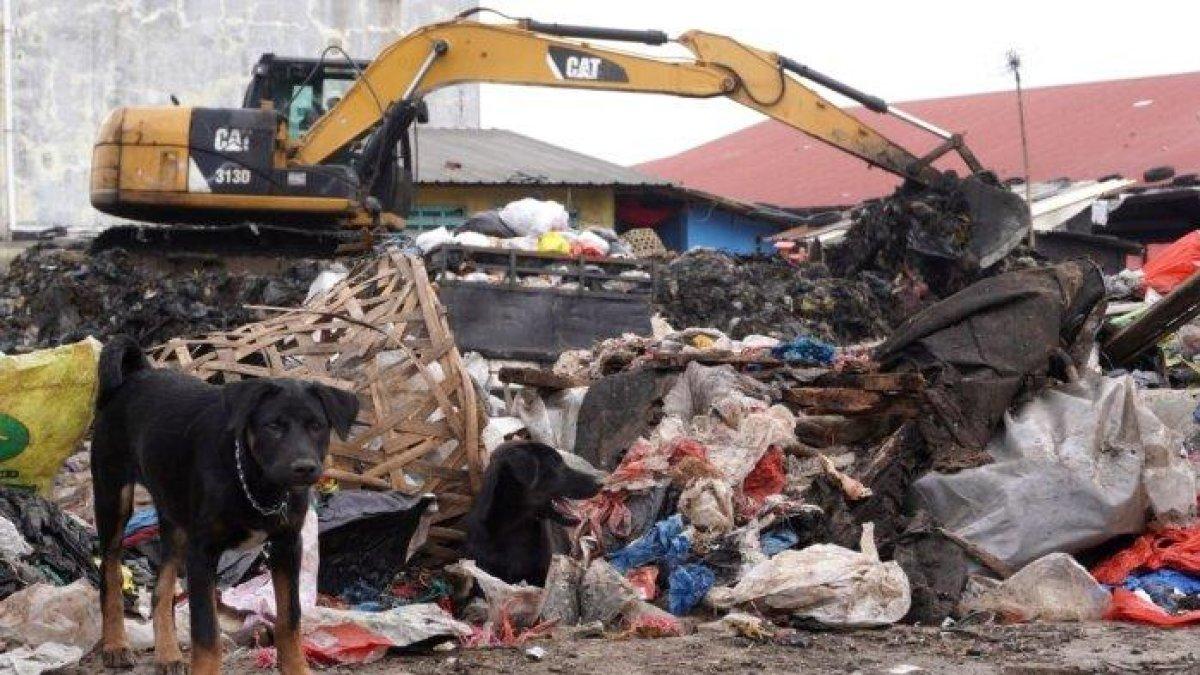 100 HARI KERJA - Petugas menggunakan alat berat beko mengumpulkan sampah untuk diangkut dengan truk di Pasar Gedebage, Jalan Soekarno Hatta, Kota Bandung, Jawa Barat, Selasa (29/4/2025).
