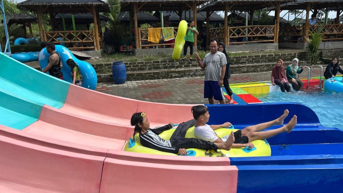 LIBUR LEBARAN KLATEN - Pengunjung bermain wahana seluncuran di kolam dengan kedalaman 1 meter, panjang 15 meter, tinggi sekira 5 meter, saat libur panjang Lebaran Umbul Pelem di Desa Wunut, Kecamatan Tulung, Klaten, Rabu (2/4/2025).