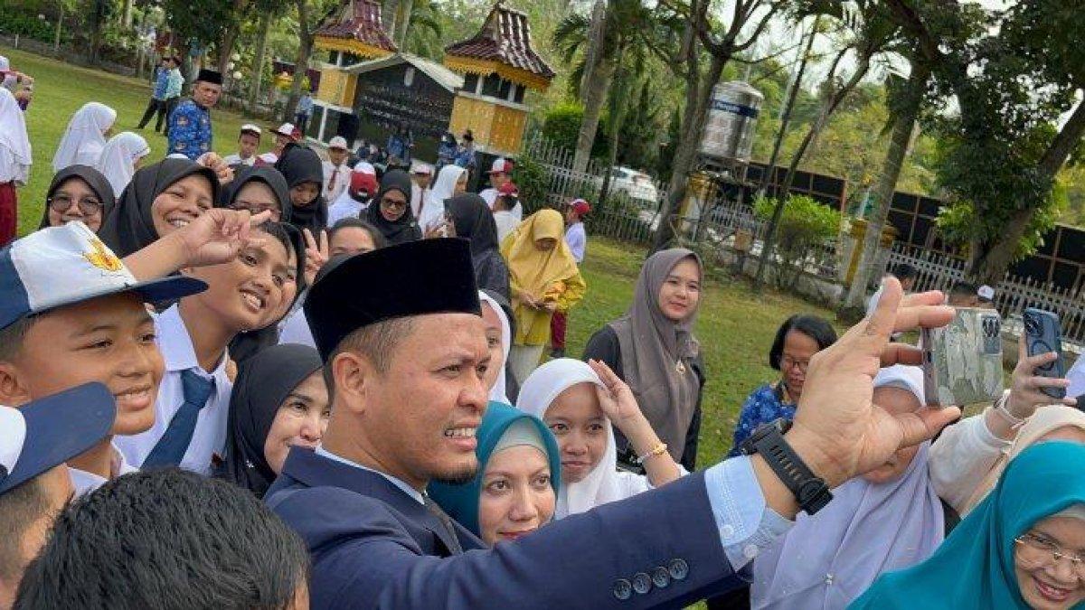 100 HARI KERJA - Wali Kota Pekanbaru, Agung Nugroho berswafoto dengan sejumlah pelajar setelah upacara Hardiknas 2025 di Lapangan MPP Pekanbaru, Jumat (2/5/2025).