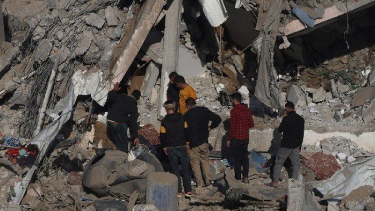 Warga Palestina memandangi puing-puing permukiman yang hancur di Rafah, selatan Jalur Gaza