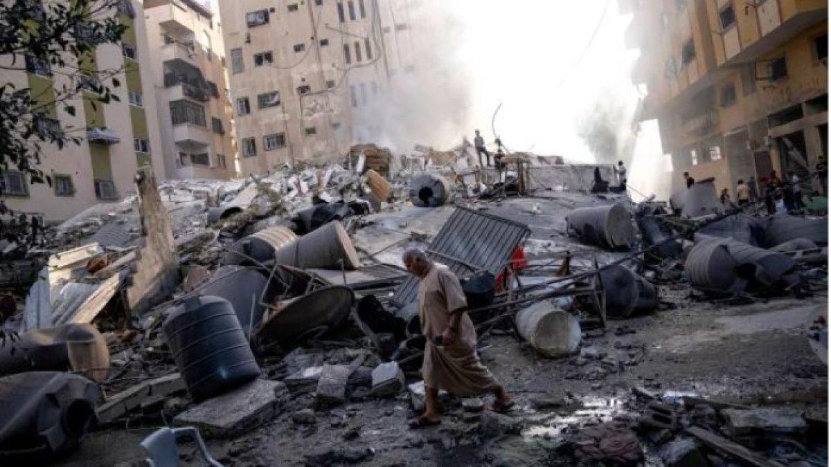 Warga Palestina memeriksa puing-puing sebuah bangunan setelah terkena serangan udara Israel, di Kota Gaza