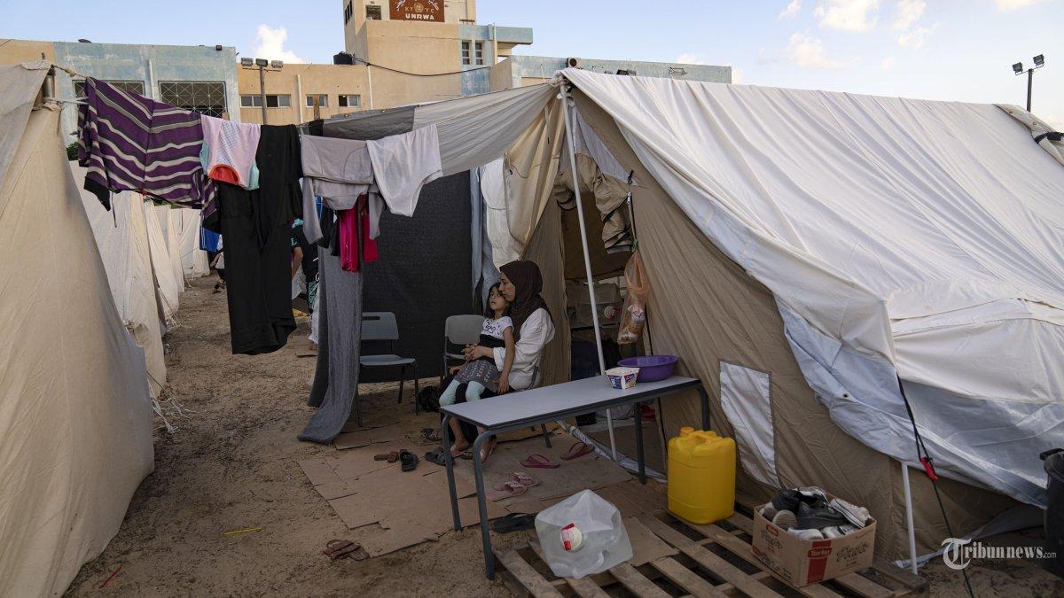 Warga Palestina yang mengungsi akibat pemboman Israel di Jalur Gaza duduk di kamp tenda yang disediakan UNDP di Khan Younis pada Kamis, 19 Oktober 2023. Ratusan warga Palestina memadati kamp tenda kumuh di Gaza selatan, sebuah gambaran yang telah membawa kembali kenangan akan trauma terbesar mereka. Pembangunan kota tenda yang dilakukan secara dadakan di Khan Younis untuk melindungi sejumlah warga Palestina yang kehilangan atau meninggalkan rumah mereka selama beberapa hari terakhir akibat pemboman hebat Israel telah menimbulkan kemarahan, ketidakpercayaan dan kesedihan di seluruh dunia Arab.