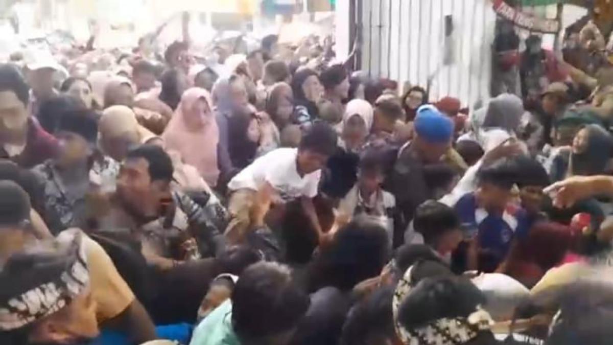 PERNIKAHAN ANAK KDM - Warga berdesak-desakan di gerbang pendopo Garut menunggu gelaran makan gratis yang merupakan rangkaian kegiatan pernikahan Wakil Bupati Garut Putri Karlina dan Maula Akbar putra dari Gubernur Jawa Barat Dedi Mulyadi, Jumat (18/7/2025) siang.