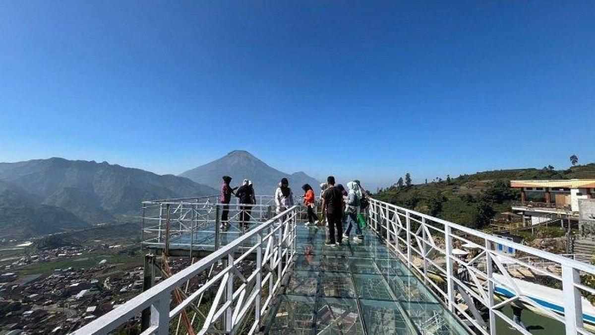 WISATA ALAM - Potret wisatawan menikmati wahana jembatan kaca di tempat wisata Pintu Langit Wonosobo, Jumat (9/8/2024). Wisata Pintu Langit dilengkapi banyak spot foto.