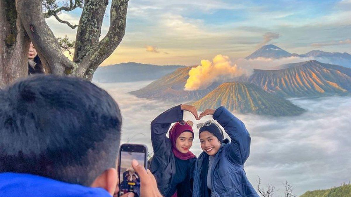 PESONA WISATA BROMO - Wisatawan berfoto dengan background lautan awan kaldera Bromo di Bukit Kingkong.