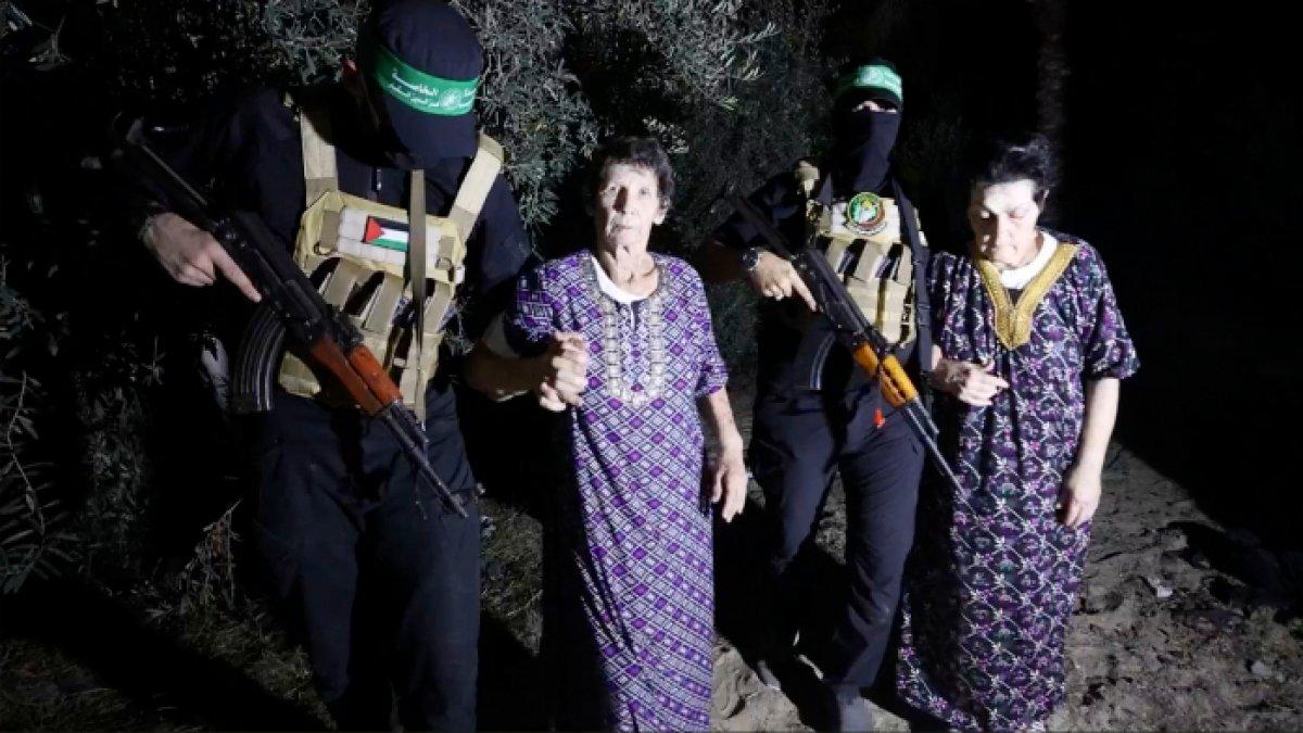 Foto hasil tangkapan atas tayangan video yang dirilis Brigade Al-Qassam melalui saluran Telegram ini memperlihatkan Yocheved Lifshitz (tengah) dan Nurit Cooper (kanan) dikawal anggota Hamas saat keduanya dibebaskan dan diserahkan kepada Komite Internasional Palang Merah (ICRC) di lokasi yang tak disebutkan, Senin (23/10/2023).