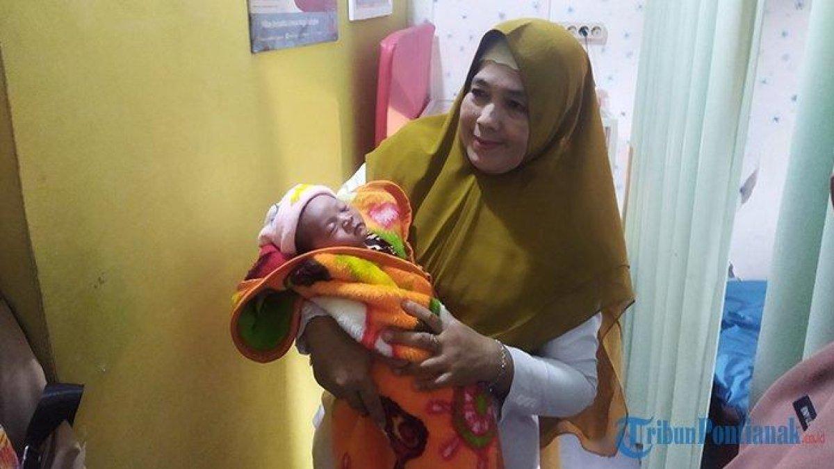Bidan Novi saat menggendong bayi perempuan yang ditemukan warga Jalan Adisucipto, Gang Teluk Permai, Kabupaten Kubu Raya pada Selasa 27 Juni 2023 pagi.