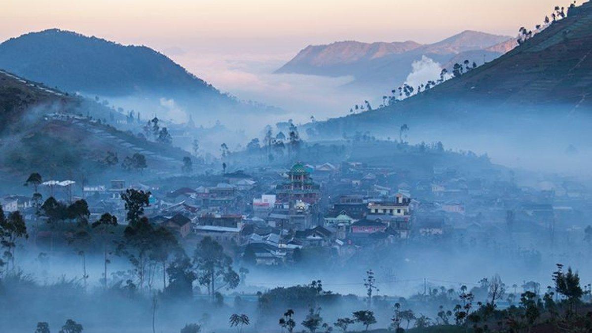 Kawasan permukiman di Dataran Tinggi Dieng yang dikelilingi kabut pada pagi hari.